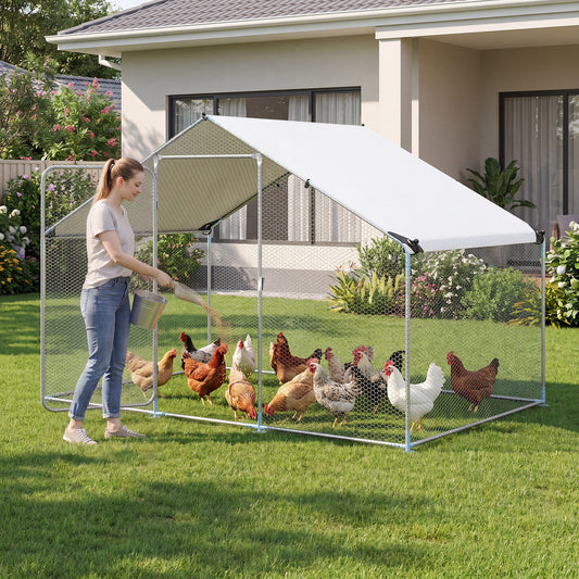 Woman feeding chickens inside the walk-in chicken run with waterproof cover in a garden setting