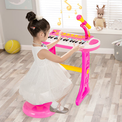 Young girl in a white dress playing the pink electronic keyboard with stool in a bright room