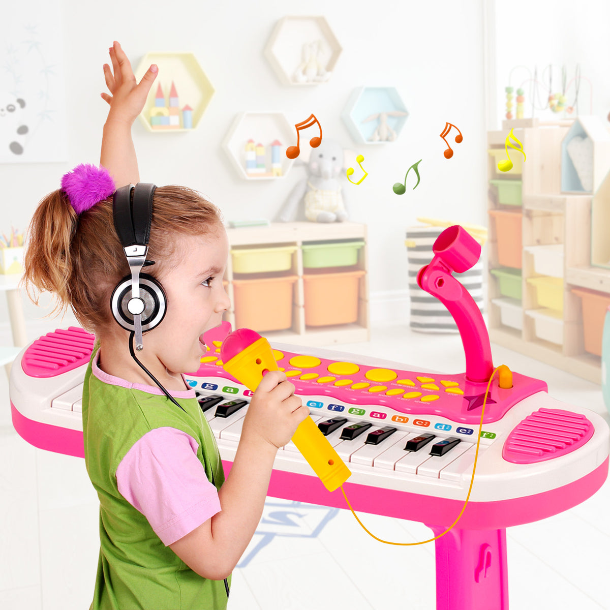 Girl wearing headphones singing into the microphone of the pink electronic keyboard