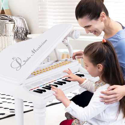 A mother and daughter play the white toy piano together in a living room setting