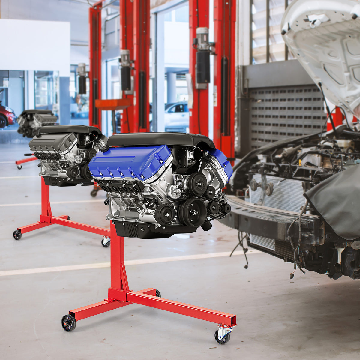 Two red engine stands holding car engines in a garage workshop