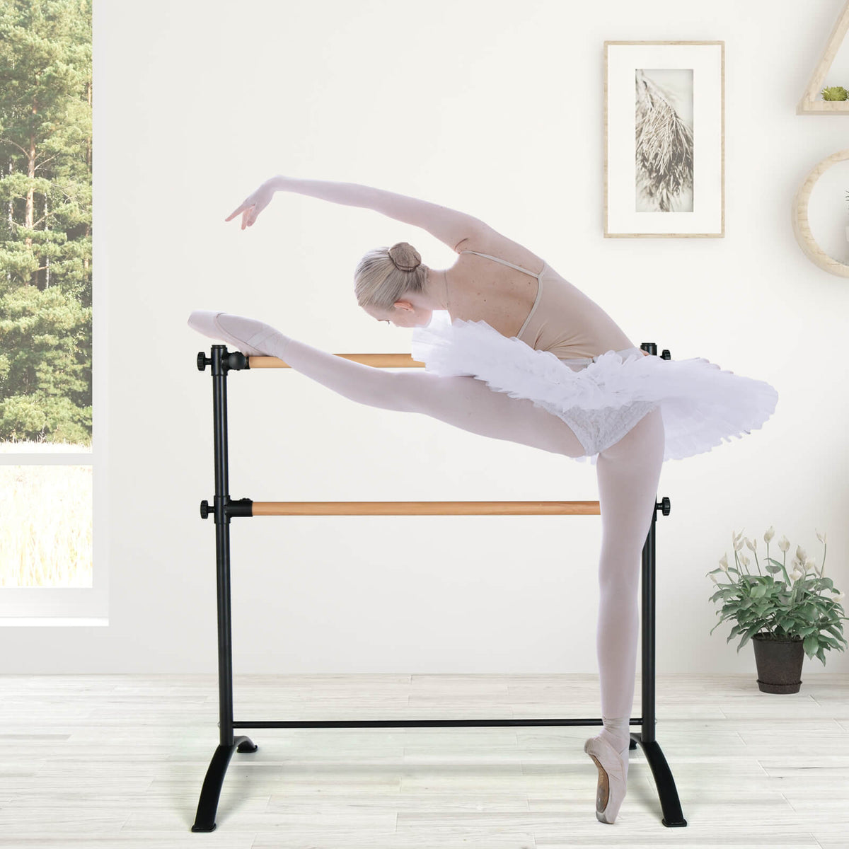 the black ballet barre supporting a ballerina performing a high leg extension in a bright room