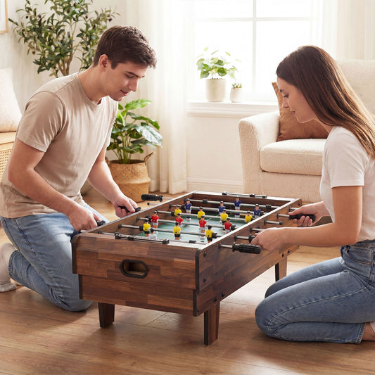 the game table being used by a man and woman kneeling on a wooden floor