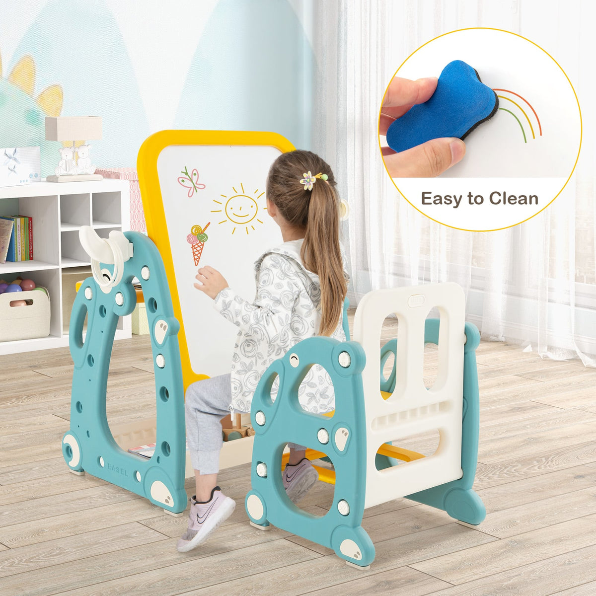 A girl drawing on the whiteboard of the kids table and chair set, with a cleaning sponge