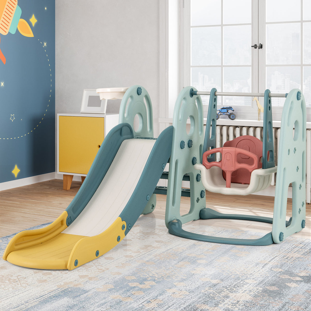 The green and blue kids slide and swing set set up in a room with toys