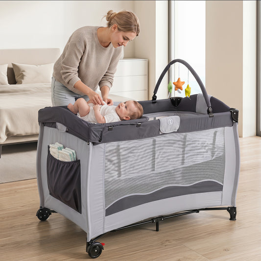 The baby playard in use with a mother changing a baby on the table