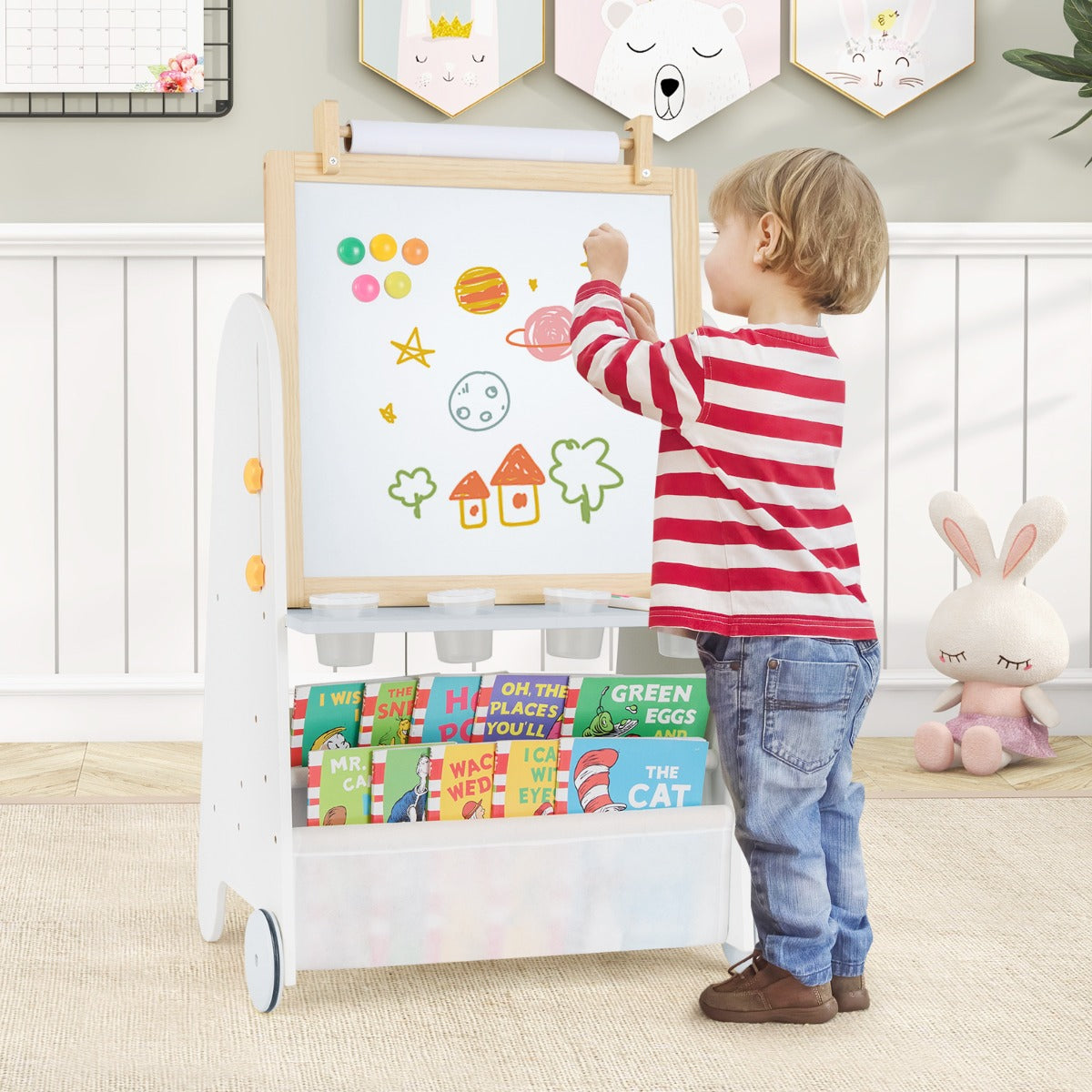 the art easel being used by a young child to draw colourful shapes on the magnetic whiteboard