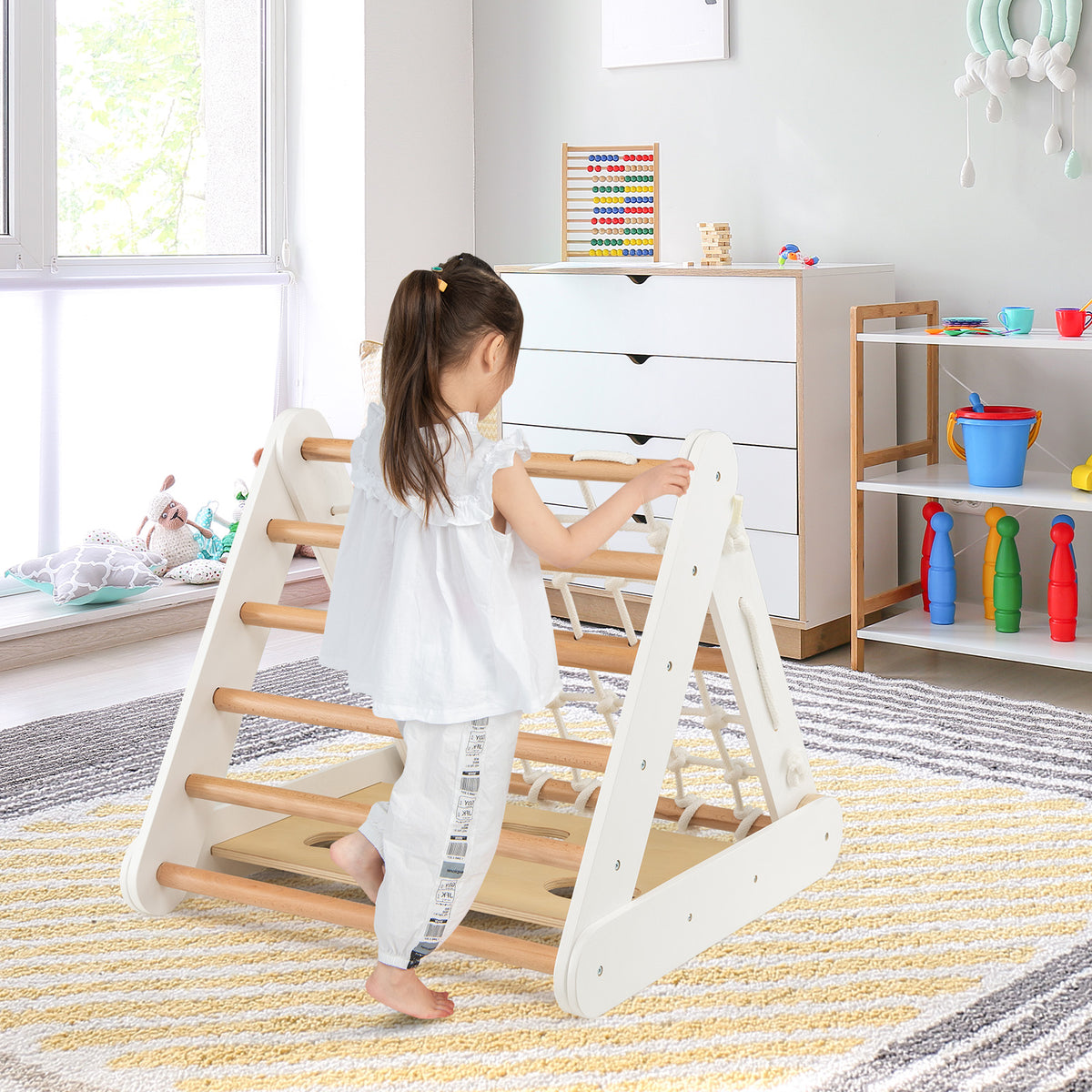 A child climbs the wooden triangle climber with a ramp and sliding board