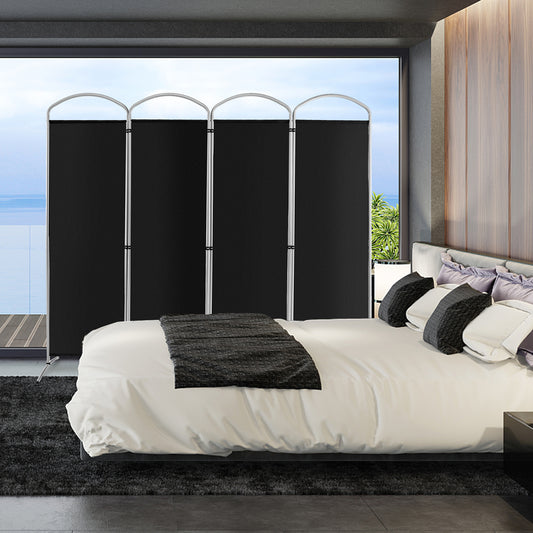 The black room divider is set up in a modern bedroom behind a bed