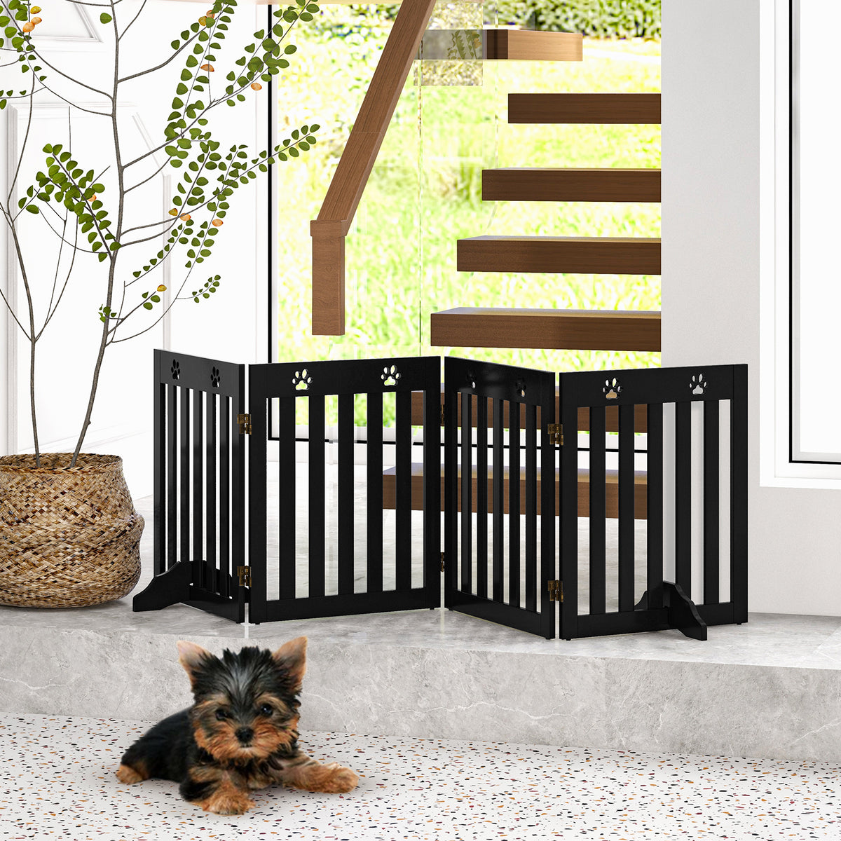 The pet gate is positioned at the bottom of stairs with a dog lying in front