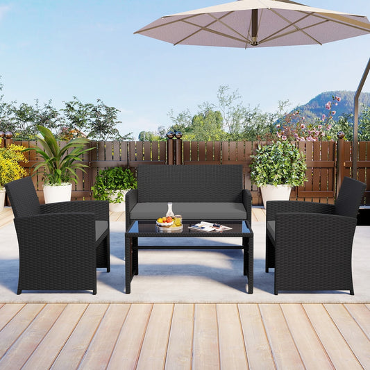 The patio furniture set arranged on a paved patio area with plants and a fence behind