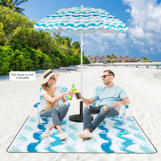 Two people sitting on foldable chairs under a beach umbrella on a picnic blanket on the sand