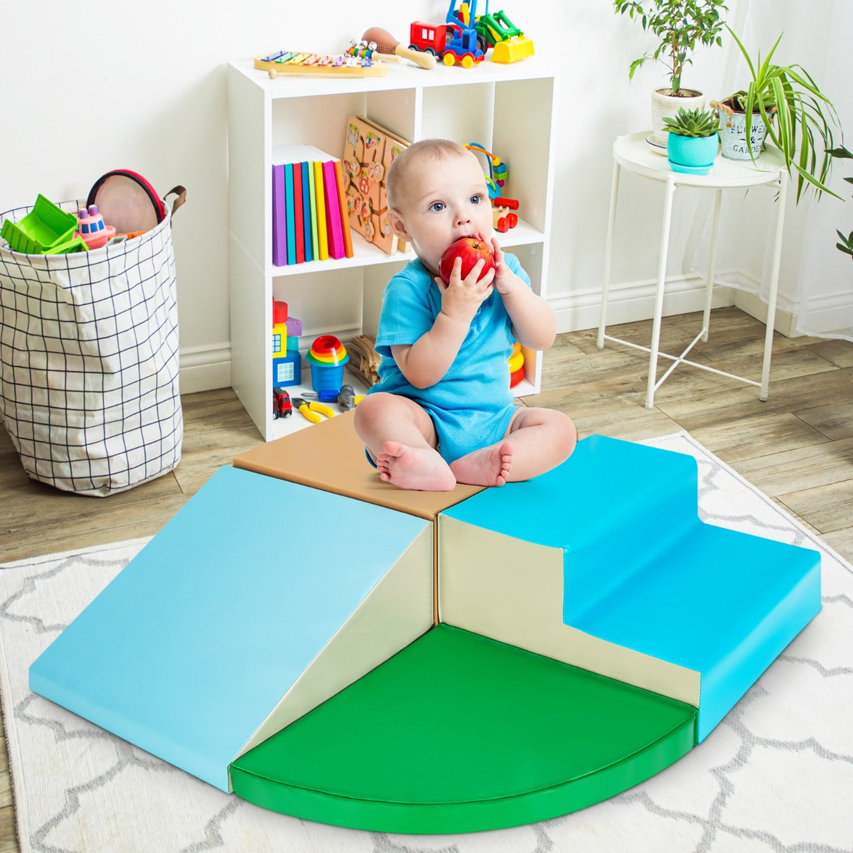 Baby sitting on the soft play set with a toy in a nursery room