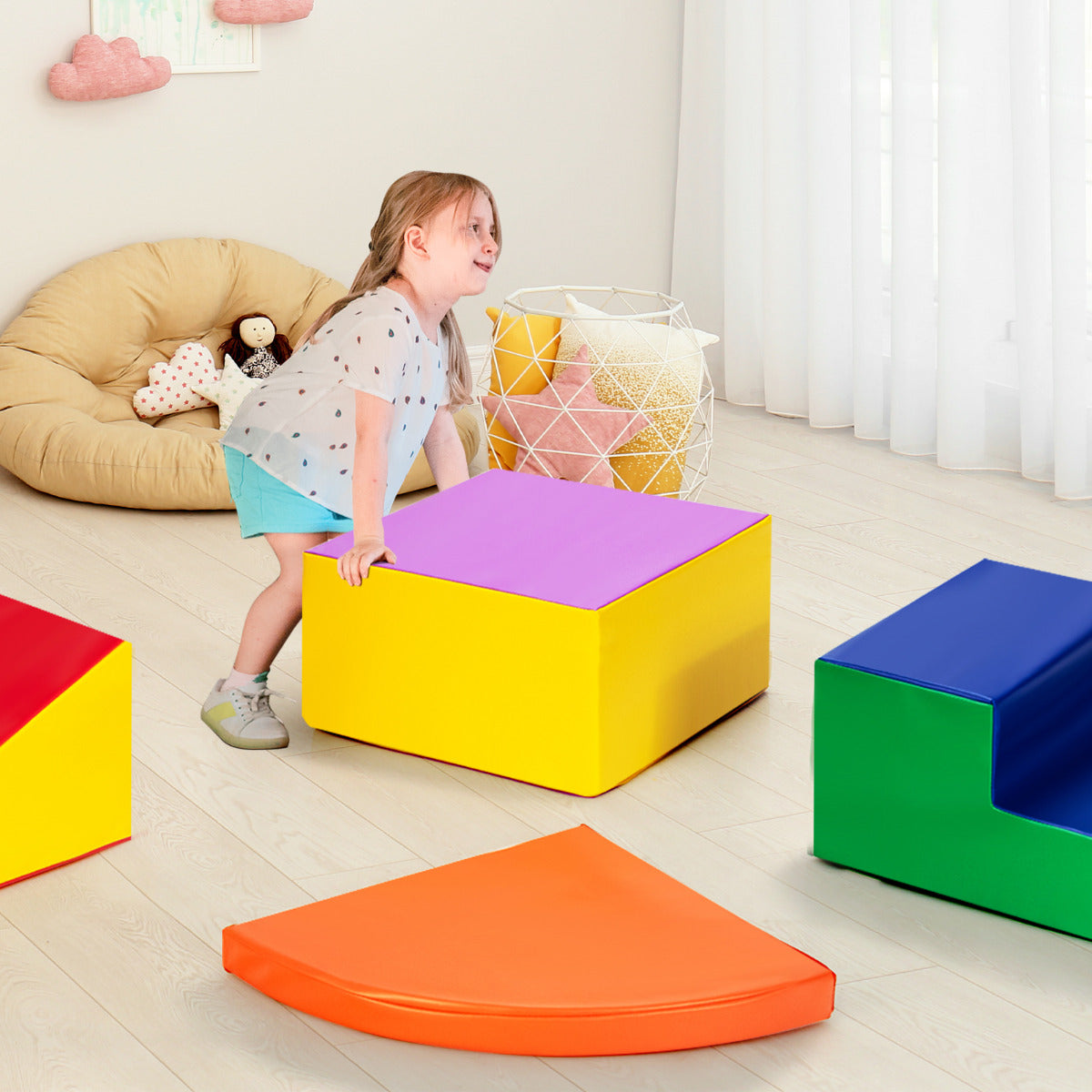 the soft play set pieces scattered on a nursery floor with a child playing