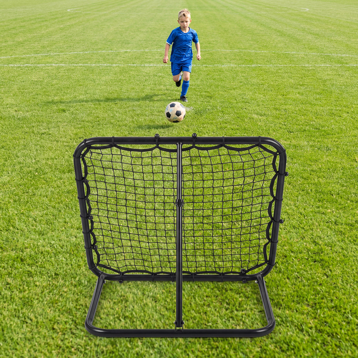 A child runs towards the bounce back net on a football pitch to receive a ball