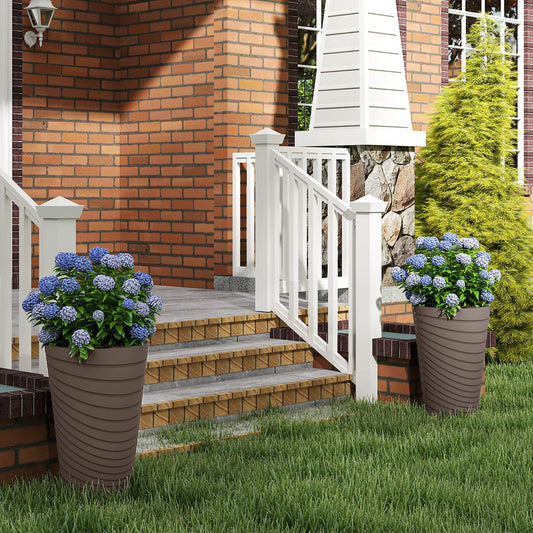 Two modern decorative planters on a house porch with plants