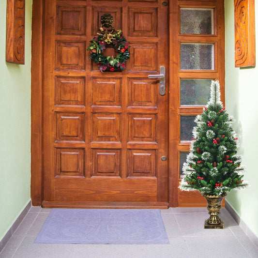 The artificial Christmas tree decorated with pine cones and berries by a front door