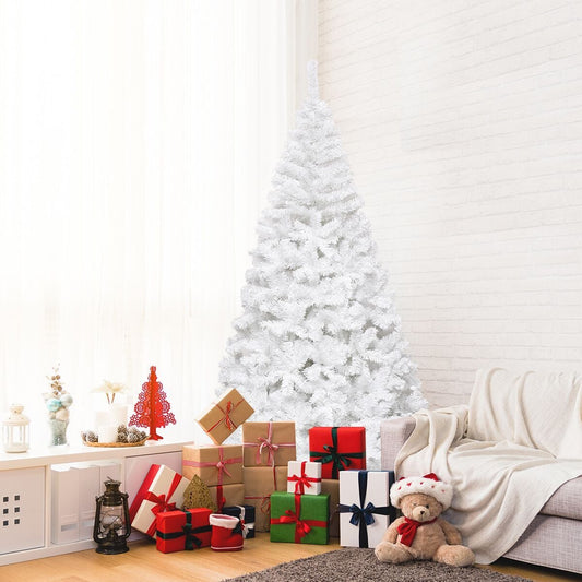 A white artificial Christmas tree decorated with presents and a teddy bear in a cosy living room setting