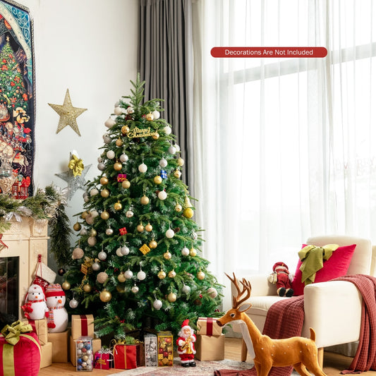 The artificial Christmas tree decorated with baubles and ornaments in a festive room setting