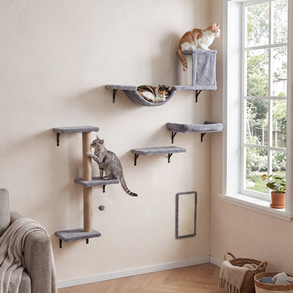 The cat furniture set arranged on a wall with three cats climbing and lounging on the shelves