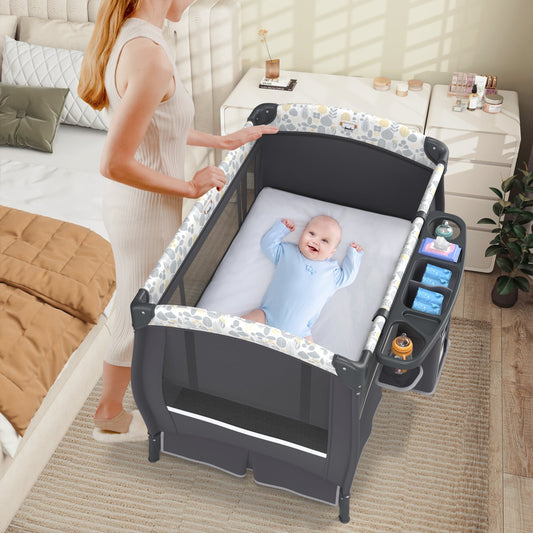 The bedside sleeper placed next to a bed with a baby lying on the mattress inside