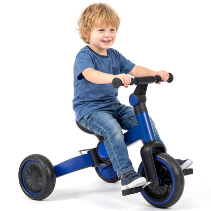 A young boy sits on the blue balance bike, smiling