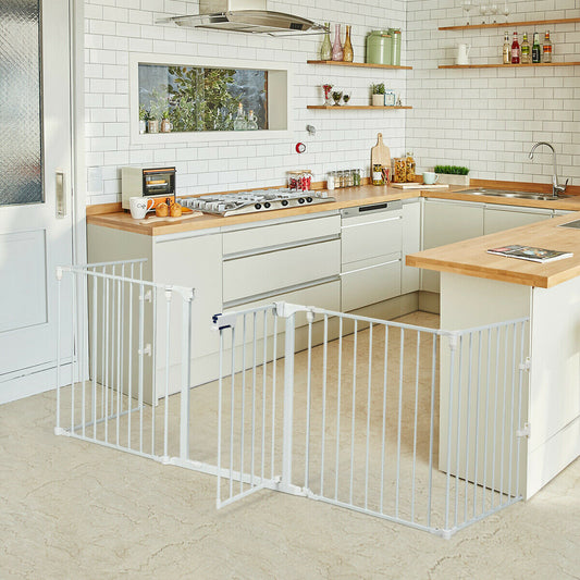 The white metal safety gate is set up in a modern kitchen area, blocking access to a stove