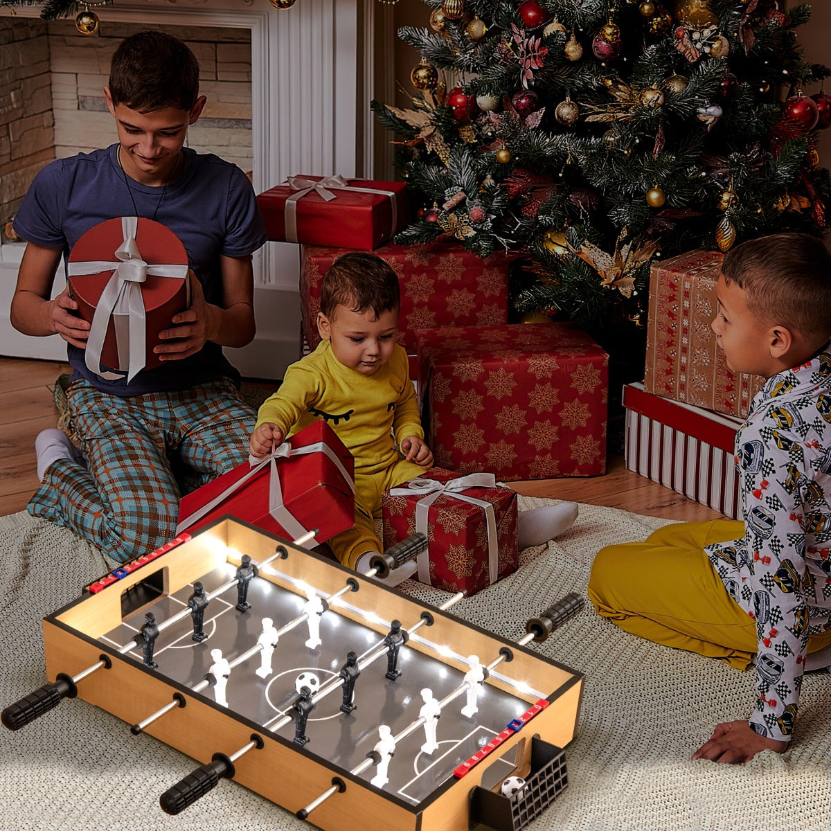Family playing a foosball game with LED lights around a Christmas tree