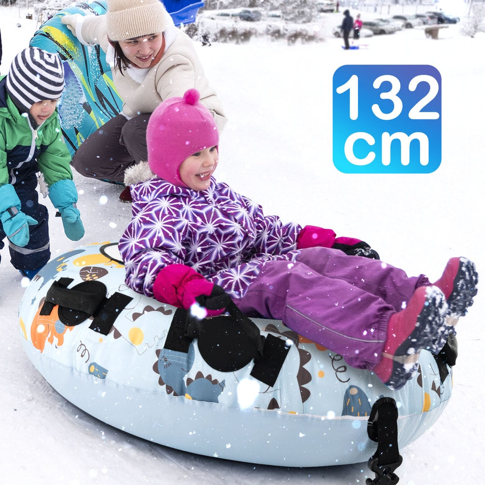 Two children and an adult enjoying a blue dinosaur patterned snow tube on a snowy slope