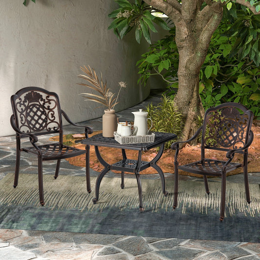 Rustic brown cast aluminum outdoor side table with two chairs in a garden setting