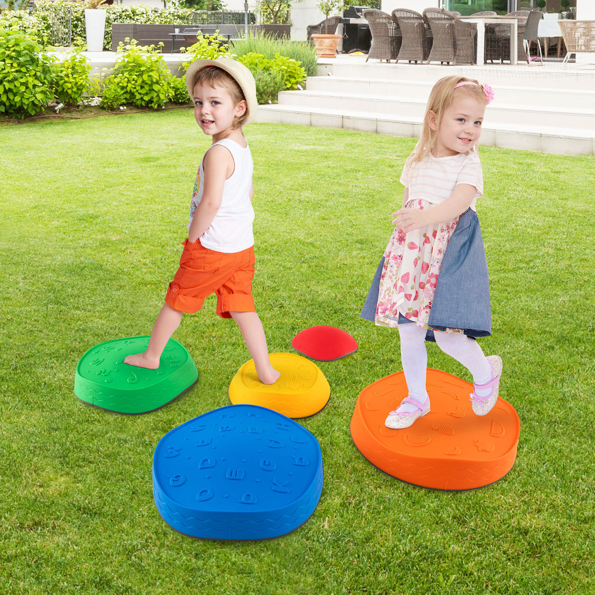 The kids stepping stones placed on a green lawn with two children playing in the garden