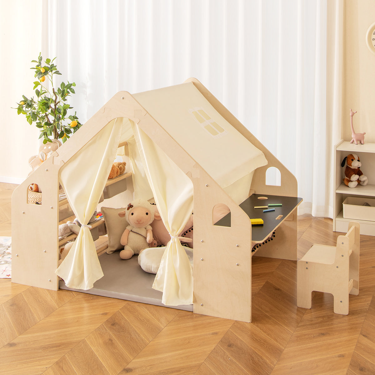 The play tent with blackboard and storage bins, set up in a room with toys and a plant