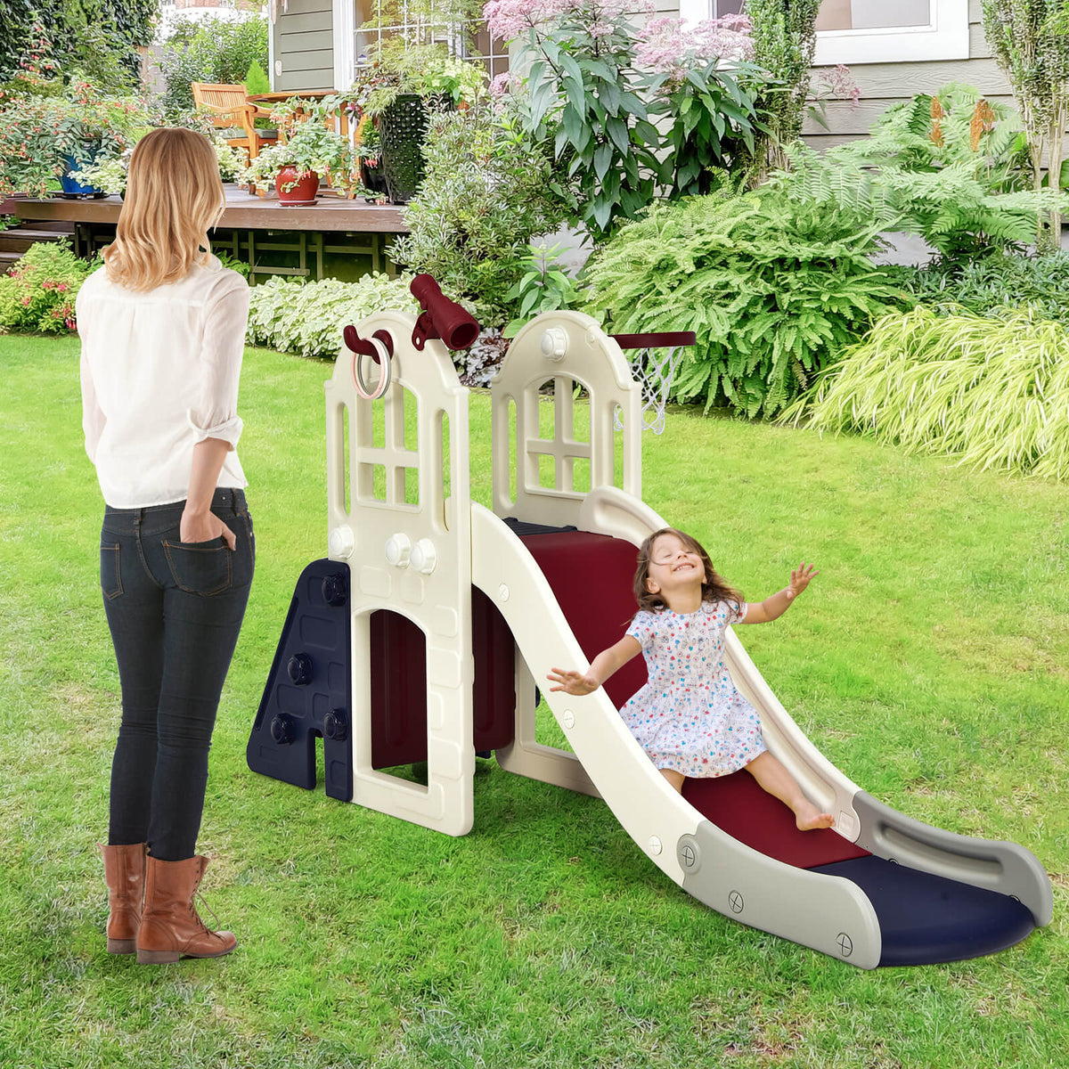 The kids slide set placed on a green lawn with a child sliding down while an adult watches