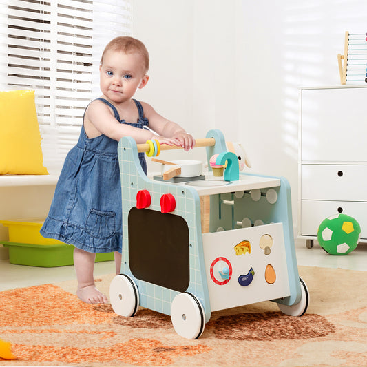 The baby walker being pushed by a toddler in a bright playroom with a white storage unit