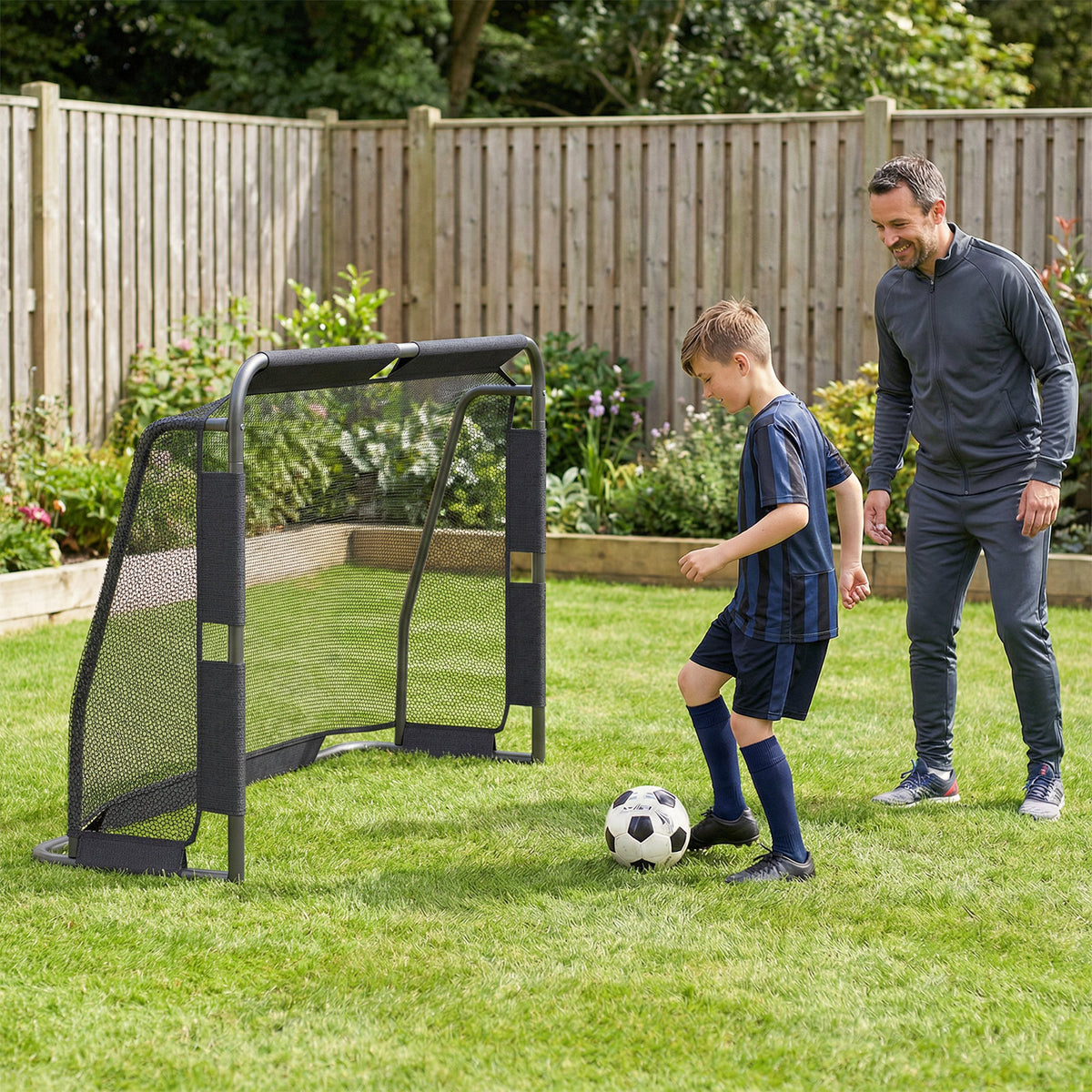 Father and son playing soccer with the goal set in a garden