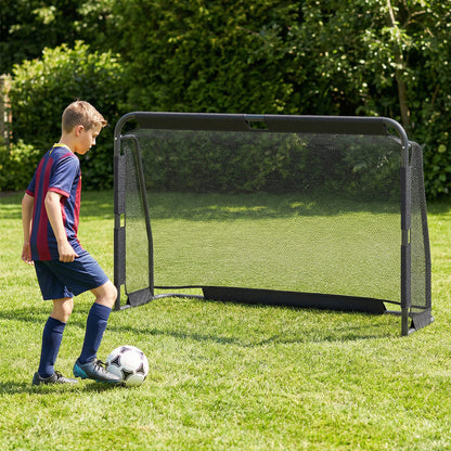 Young boy playing with the soccer goal set in a garden