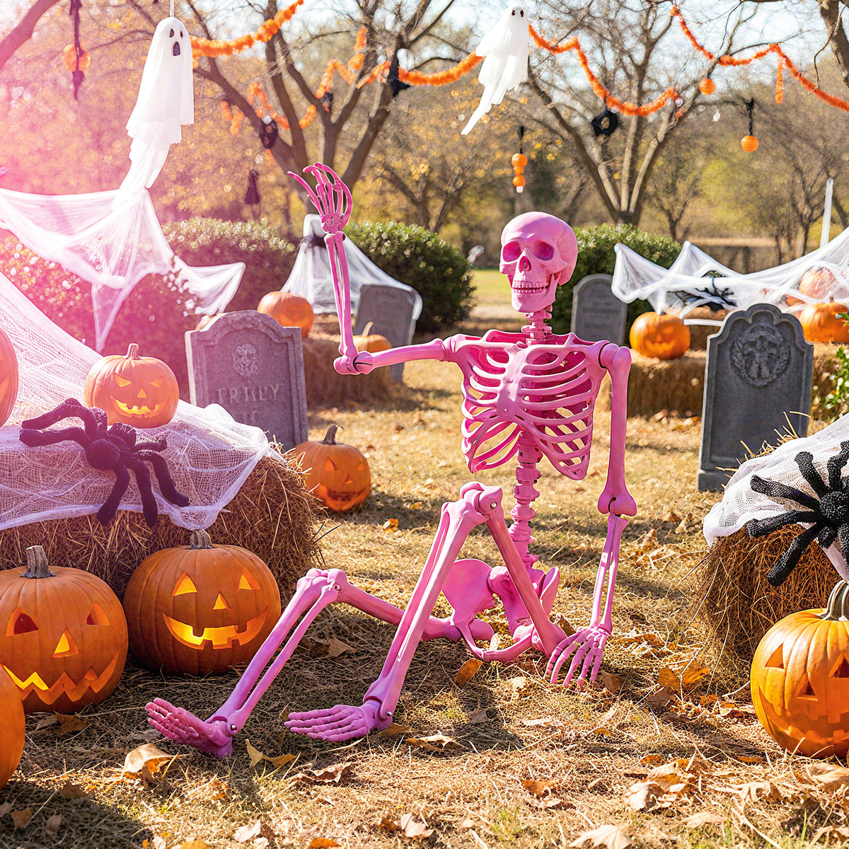 The Halloween skeleton decoration sitting on hay bales in a garden with pumpkins