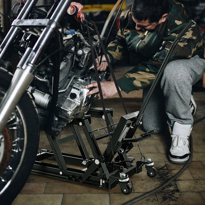 Mechanic working on a motorcycle raised by a black lift jack