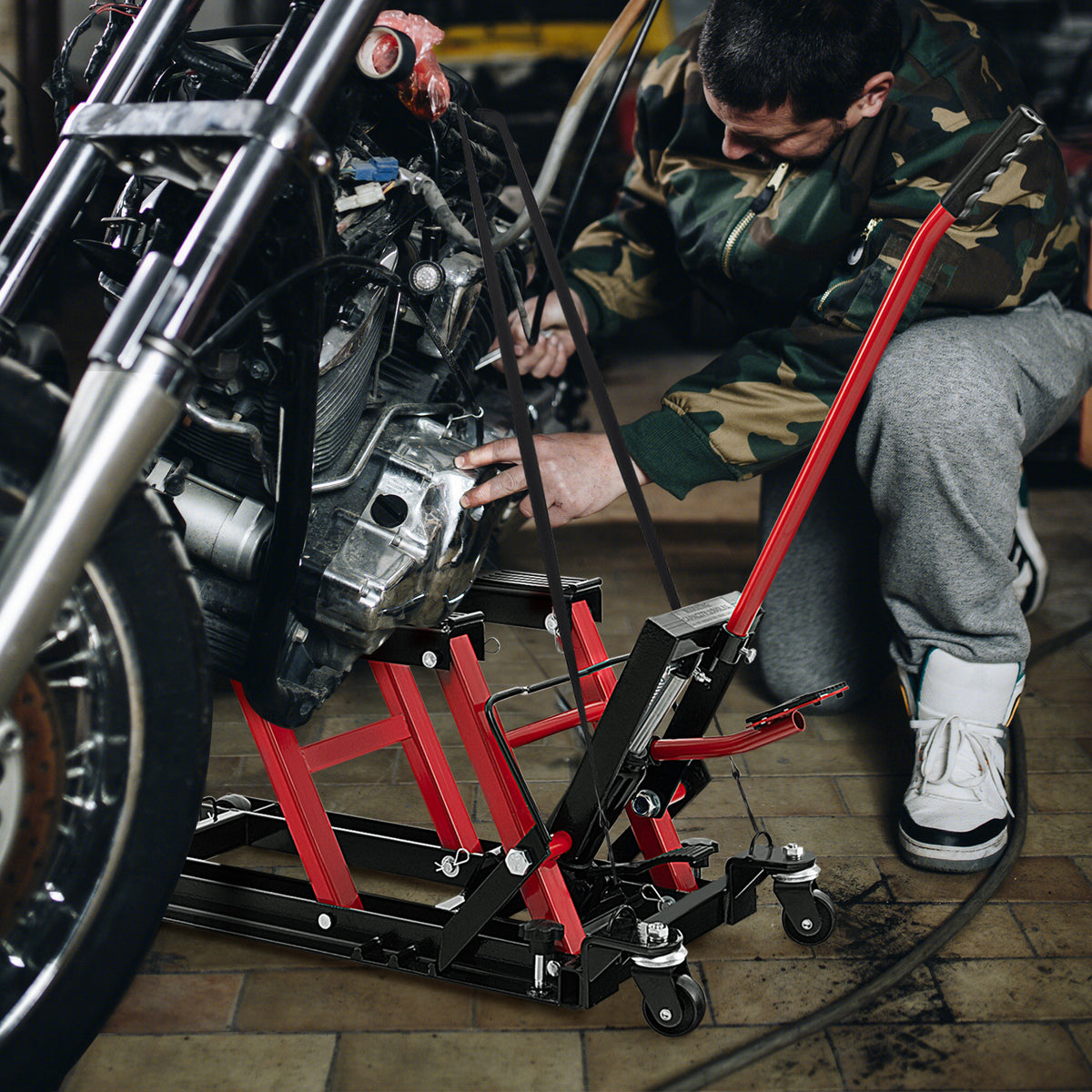 The motorcycle lift jack positioned under a motorbike while a person performs repairs