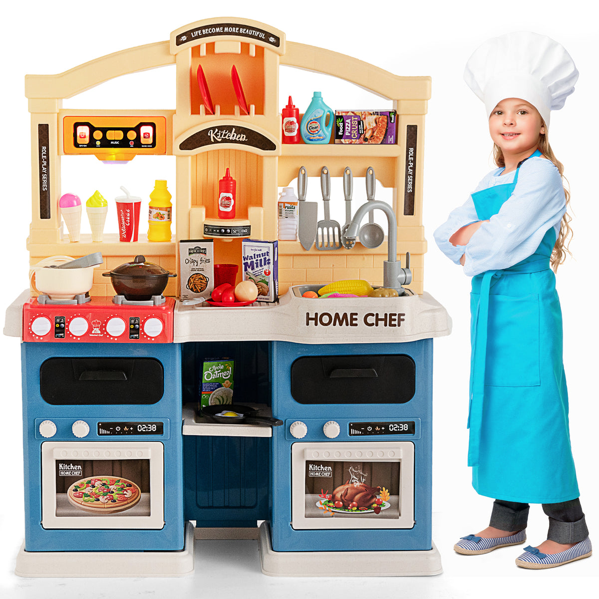 Girl in chef hat and apron standing by the blue and yellow play kitchen set