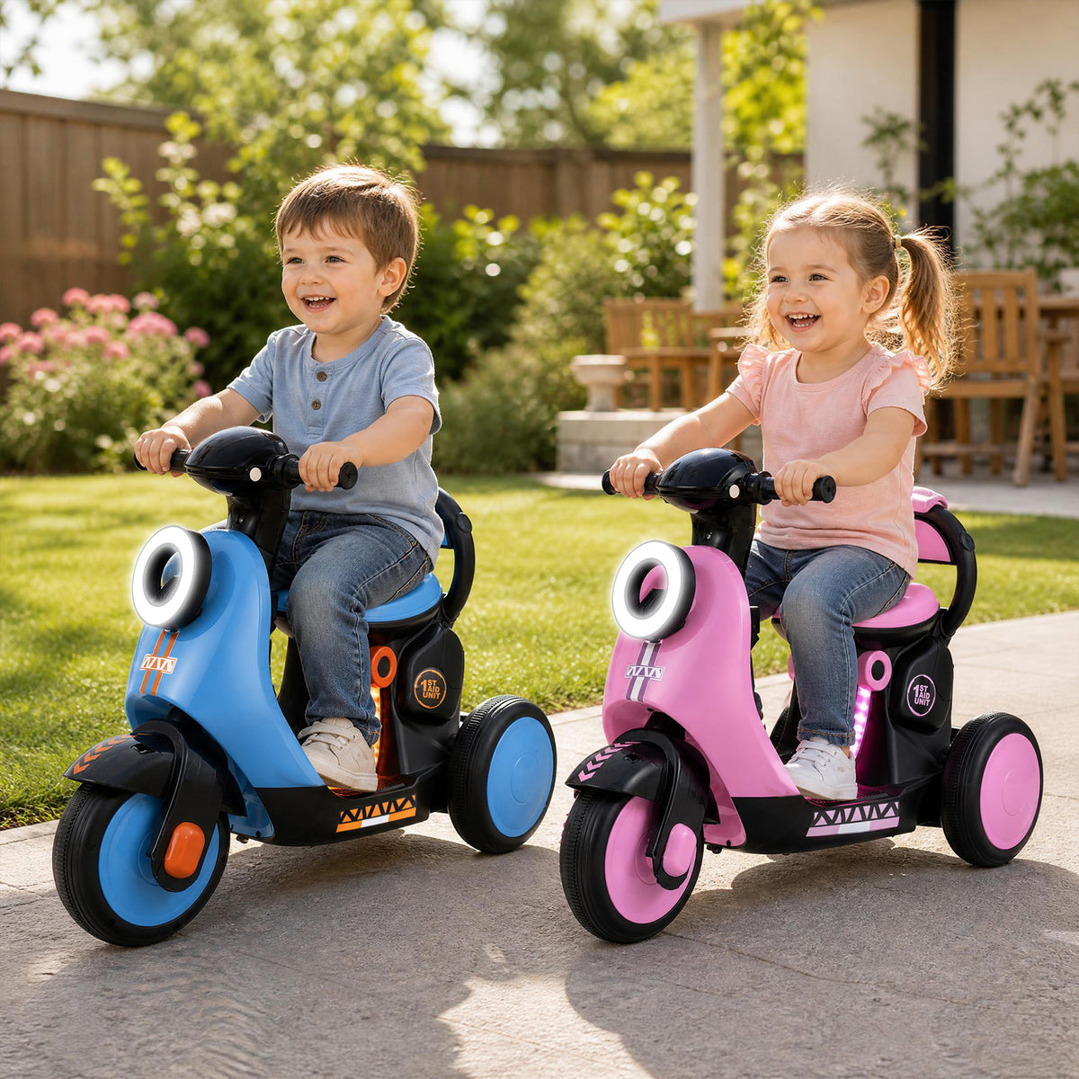 Two smiling children, a boy and a girl, ride blue and pink kids electric motorbikes in a garden setting