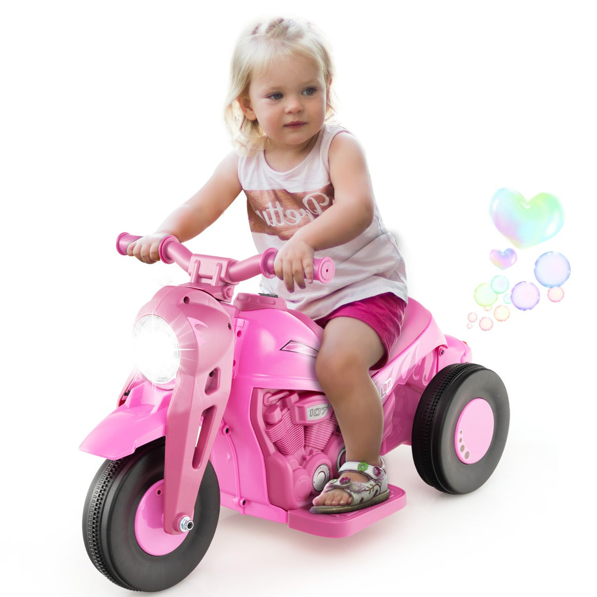 A toddler rides the pink kids electric motorbike, with bubbles floating around