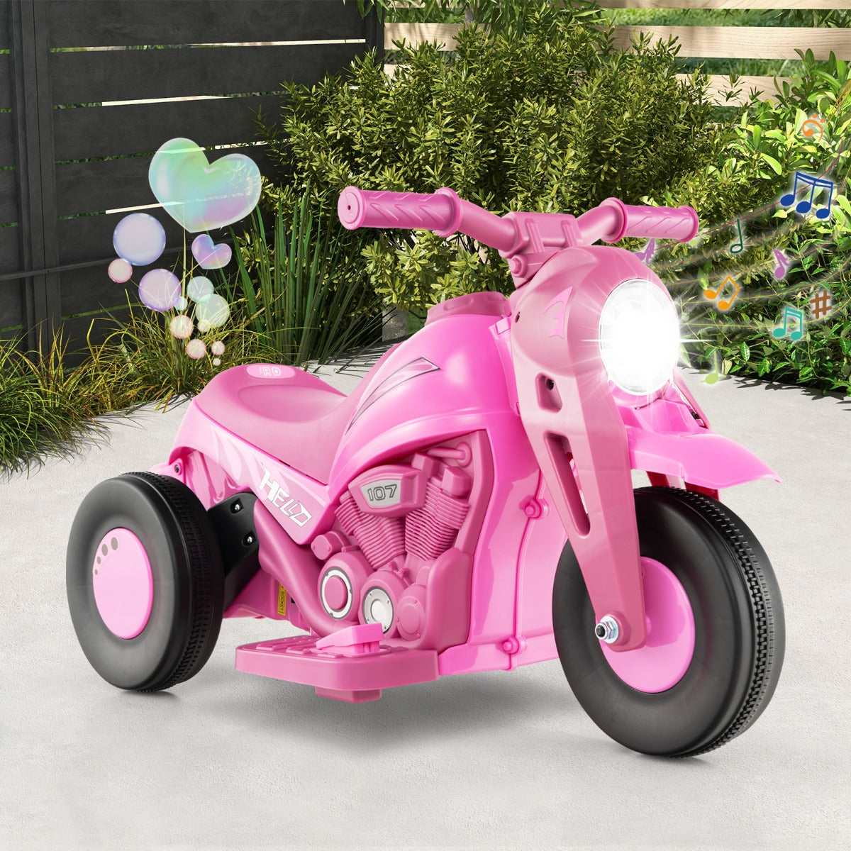 The pink kids electric motorbike with lights on and bubbles floating around it, shown outdoors