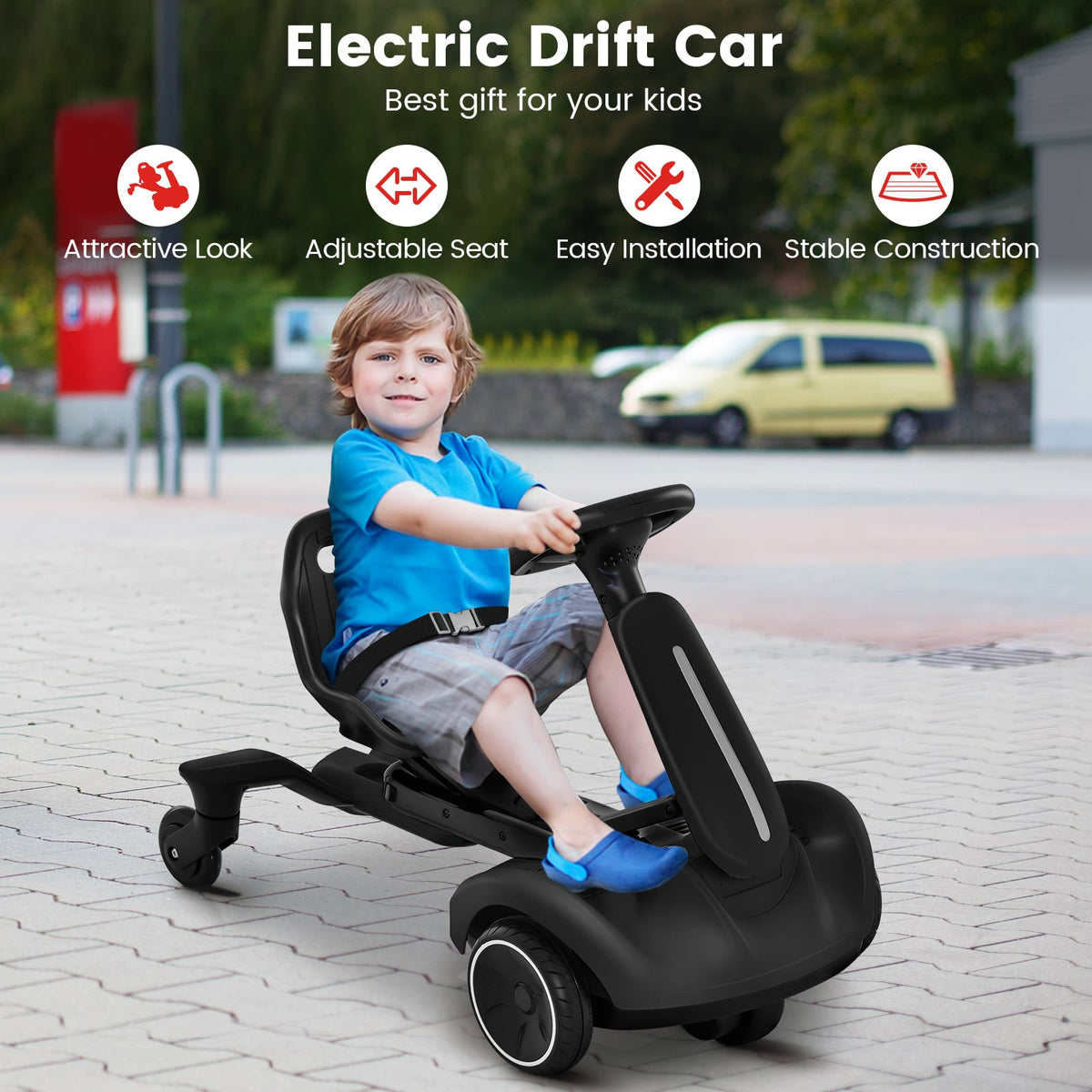 The kids electric car being driven by a young boy on a paved driveway