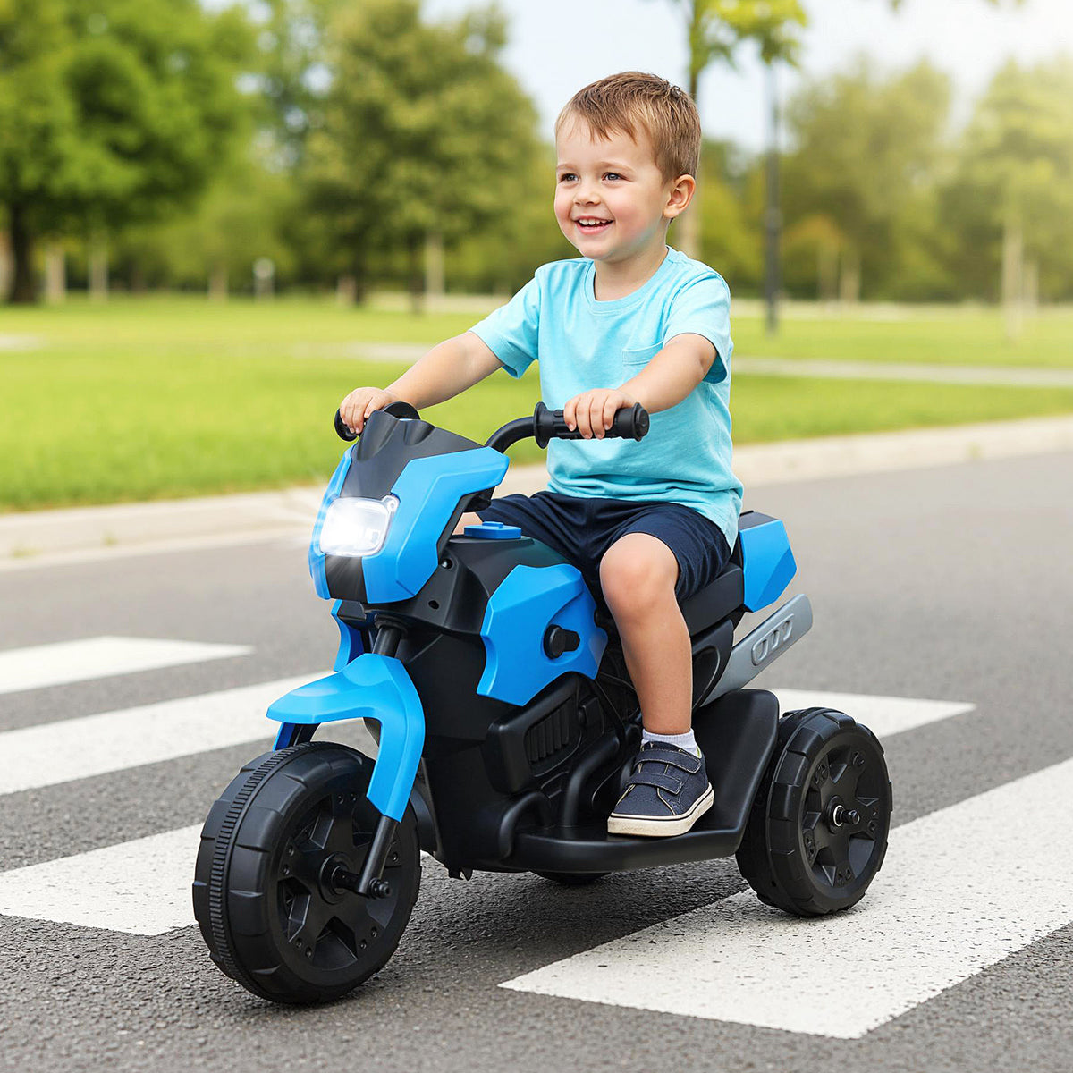 A young boy riding the kids electric motorbike on a paved path outdoors