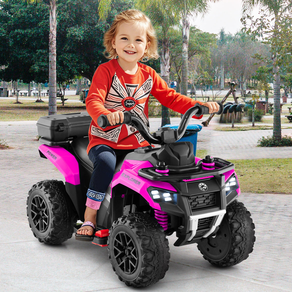 A young child rides the pink kids electric quad bike outdoors