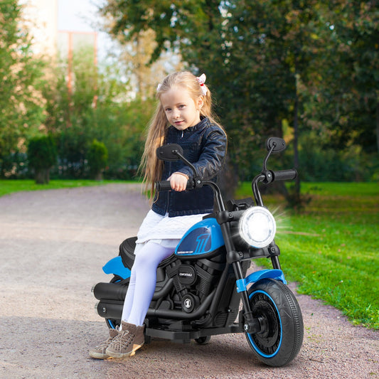 The navy blue kids electric motorbike with a bright headlight parked on a path