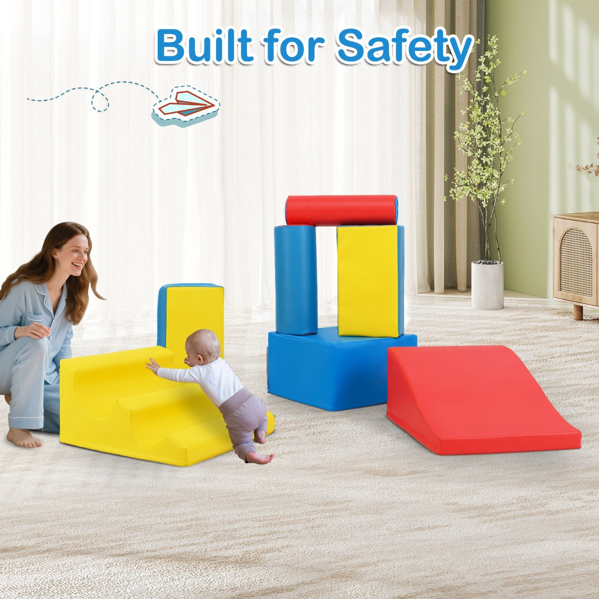 A woman and a baby interacting with the soft play sets in a living room