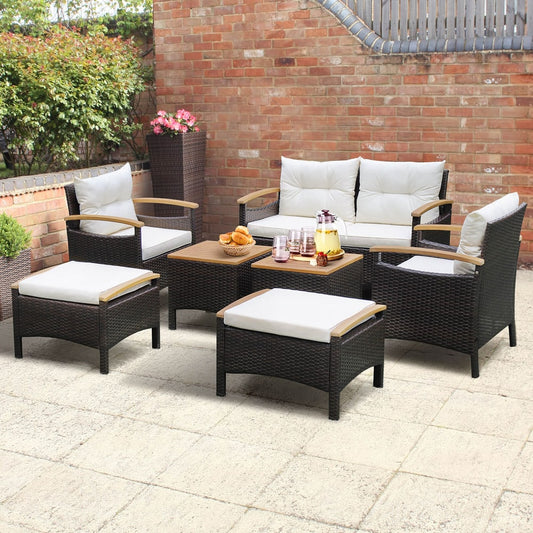 The outdoor rattan sofa set is shown in use on a sunny patio with drinks on the tables