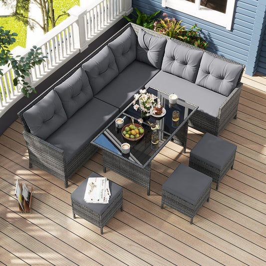 grey rattan corner sofa with glass topped table and four stools on a wooden deck